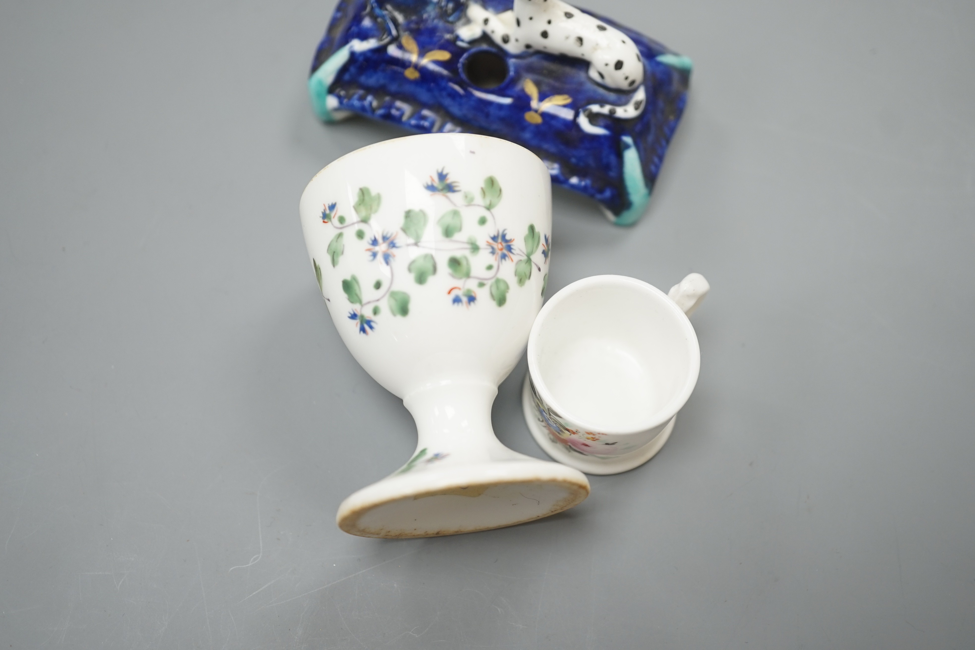 A mid 19th century Staffordshire porcelain Dalmatian pen holder and a cornflower spray egg cup and a miniature mug, tallest 6cm
